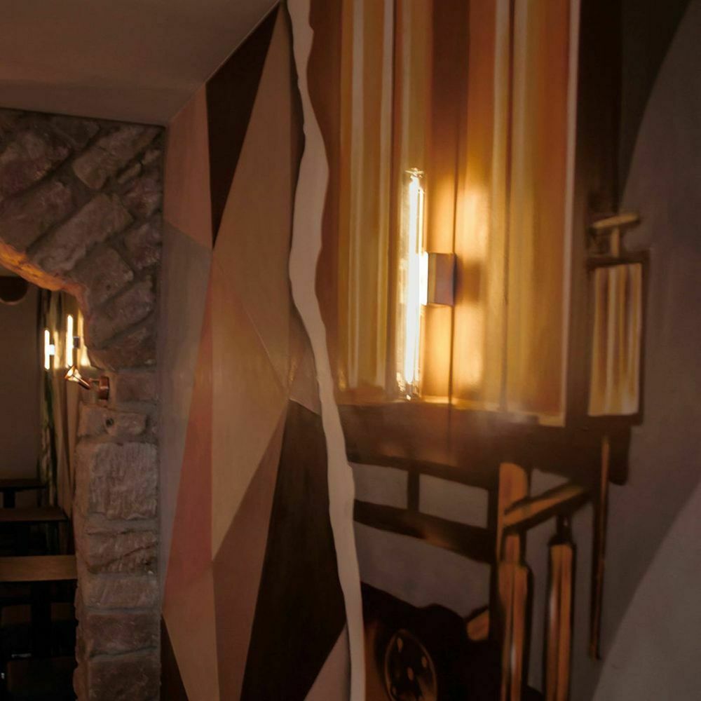 S14d LED Linienleuchte an Wand mit Kunstwerk in warmweißem Licht, ideal für Hotel und Gastronomie.