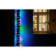 LED Mini Lichterschlauch 10m mit Lichtsensor Timer 130 bunte Dioden batteriebetrieben IP44 an einer Wand mit Fenster.