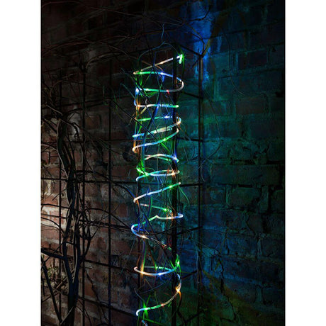 LED Mini lysslange 5 m med lyssensor, timer, 65 fargede dioder, batteridrevet, IP44, på en dekorativ vegg.