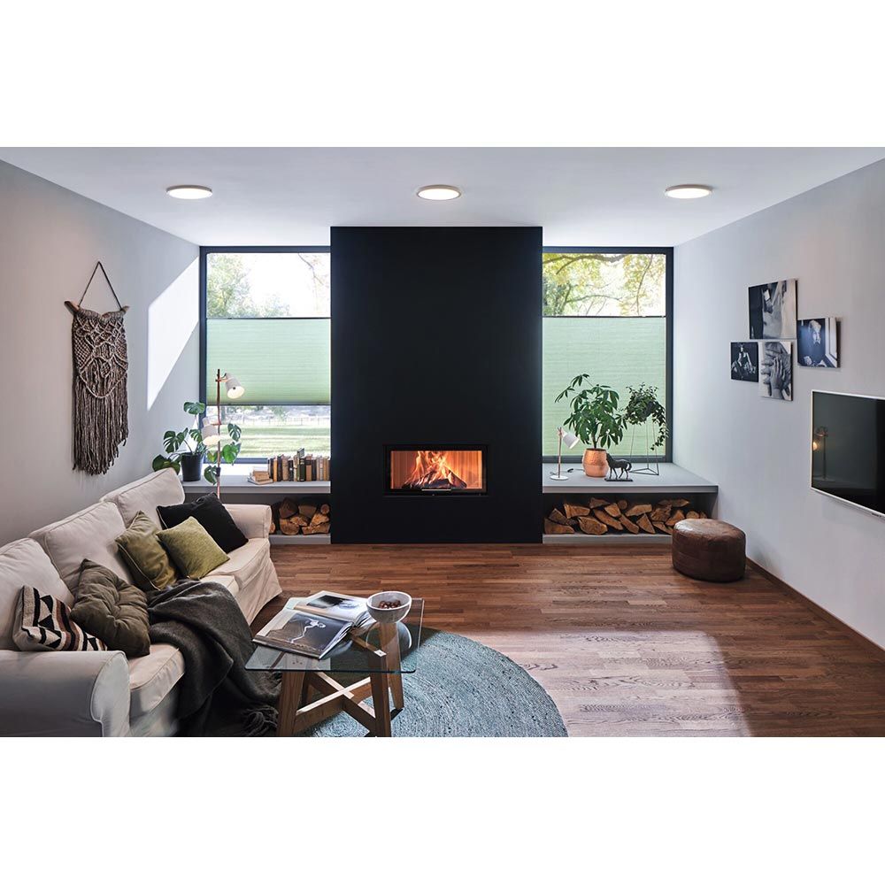 Gemütliches Wohnzimmer mit LED-Panels, Kamin und modernem Interieur, das den runden Abia Chrom-Matt LED-Panel betont.