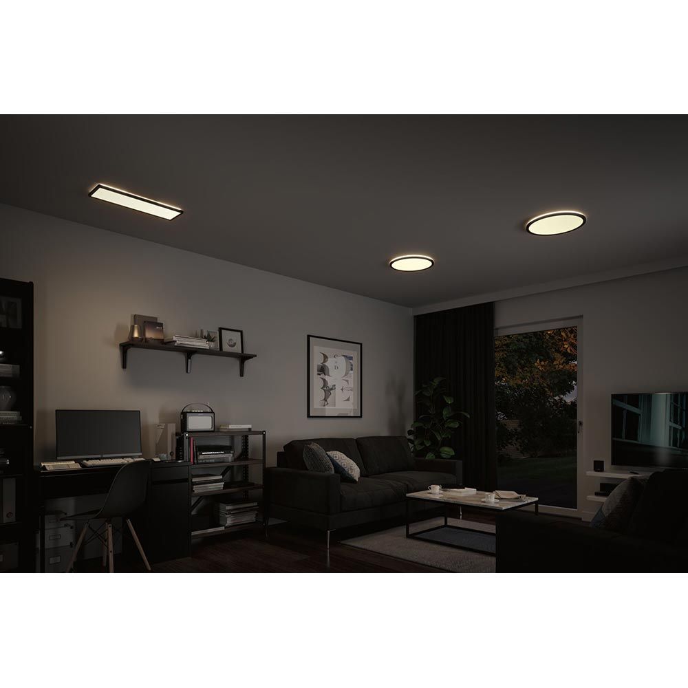 Zimmmeransicht mit LED Decken Panels Atria Shine in Schwarz, warmweißes Licht und gemütlicher Atmosphäre.