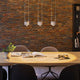 LED Pendelleuchte Aldan 3-flammig 3x9W über einem modernen Esstisch mit Holzplatte.