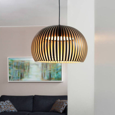 LED Atto 5000 wooden pendant light Ø 34 cm above a black sofa in the living room.