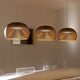 LED Pendelleuchte Atto 5000 aus Holz Ø 34cm über einem Esstisch mit warmem Licht und elegantem Design.