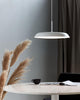 LED Pendelleuchte Piso mit skandinavischem Minimalismus über einem Tisch mit Kaffee und Notizen.