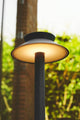 LED Pollerleuchte Justina Solar IP44 mit klassischem Design und Bewegungssensor in naturnahem Umfeld.