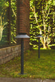 LED Pollerleuchte Justina Solar IP44 im Garten, perfekt zur Beleuchtung von Einfahrt und Wegen.