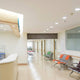 Helle, moderne Krankenhausflur mit LED-Downlights und Wartebereich mit Stühlen.