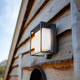 LED-Solar-Außenleuchte Curtis mit Bewegungsmelder an einer Holzfassade.