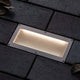 LED Solar Bodeneinbaulampe Aron mit Sensor IP67 3000K in gepflastertem Untergrund, strahlt warmes Licht aus.