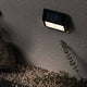 LED Solar Stufen Wand- & Treppenleuchte IP44 3000K Anthrazit an einer Wand montiert, umgeben von Steinen.