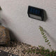 LED Solar Stufen Wand- & Treppenleuchte IP44 3000K Anthrazit an einer Wand installiert, ideal für den Außenbereich.