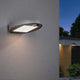 LED Solar Wandlampe Ryse mit Bewegunsmelder IP44 3000K Weiß an Außenwand montiert, optimale Beleuchtung bei Dämmerung.