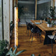 LED Stehleuchte Columna aus Stein Weißperle in einem modernen Essbereich mit Holztisch und Pflanzen.