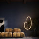 LED Stehleuchte Crochet 3000K in elegantem Design neben einem stylischen Sofa.