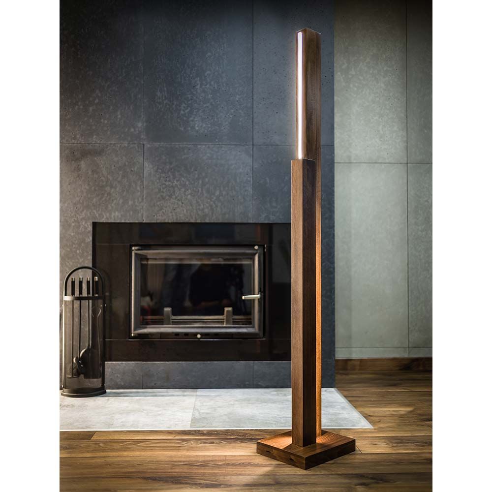 LED Stehleuchte Manhattan mit Touch-Dimmer in Nussfarbe, 3500lm, vor modernem Kamin mit Holzfußboden.