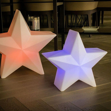 LED Stern Nova Akku + Solar IP65 lichtgevende sterren in rood en blauw op een houten ondergrond.