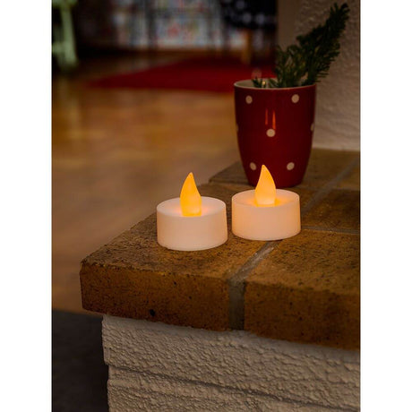 LED-Tealight 2er sett stor 2 varmhvite dioder batteridrevet på et bord med plante i bakgrunnen.