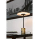 LED Tischlampe HOSHI Goldfarben-Satin, Schwarz auf einem Tisch mit urbanem Hintergrund