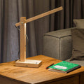 LED Tischlampe Tukan mit Touch-Dimmer in Eiche, moderne Tischbeleuchtung auf einem Holz-Esstisch.