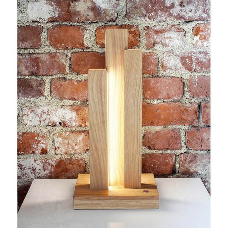LED Tischleuchte Manhattan Touch-Dimmer 1470lm Eiche-Geölt auf einem Tisch mit Backsteinwand im Hintergrund.