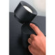 LED Wand- & Tischleuchte Puric Pane mit Touch-Dimmer Schwarz, Hand aktiviert den Touch-Dimmer auf schwarzem Tisch.