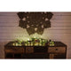 LED Tropfenlichterkette 50 Warmweiße Dioden weißer Draht dekoriert auf einem Holztisch mit Naturkranz.