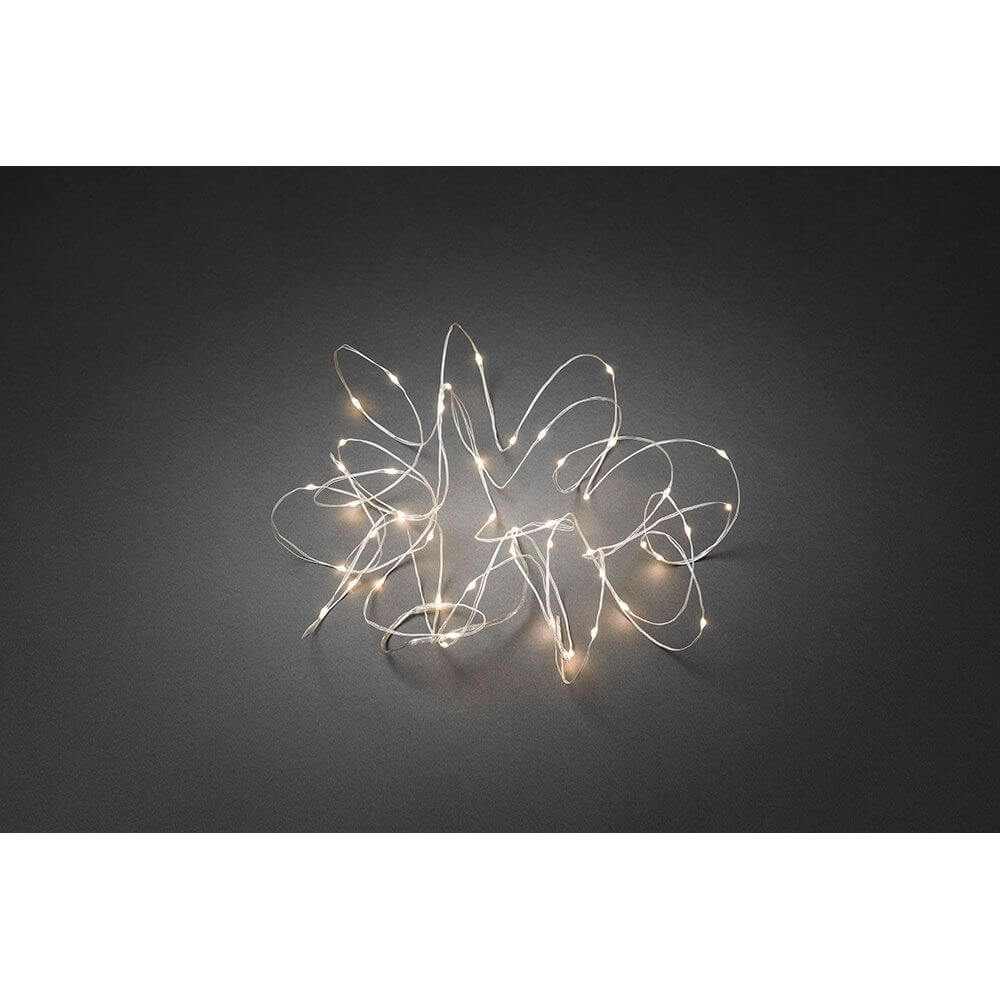 LED Tropfenlichterkette 50 Warmweiße Dioden weißer Draht auf dunklem Hintergrund, stimmungsvolles Licht.