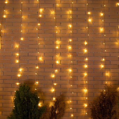 LED Vorhang-Lichterkette Luceo IP44 an einer Ziegelwand mit stimmungsvollem Licht.