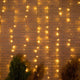 LED Vorhang-Lichterkette Luceo IP44 an einer Ziegelwand mit stimmungsvollem Licht.