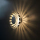 LED Wand- & Deckenleuchte Flare S Silberfarben mit strahlendem Lichtdesign an der Wand.