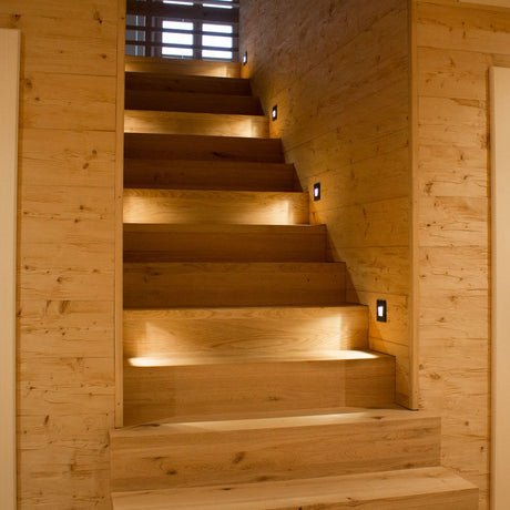 LED-Wandeinbaustrahler Sys-Wall 68 beleuchtet elegante Holztreppe im modernen Interieur.