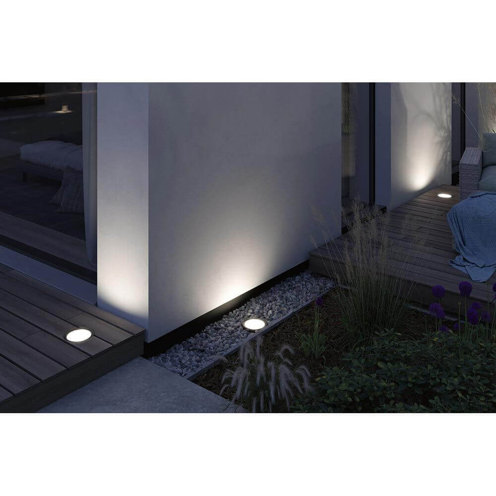 LED Einbau-Wandfluter Ocos leuchtet Wände und Pflanzen in einem modernen Außenbereich.