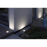 LED Einbau-Wandfluter Ocos leuchtet Wände und Pflanzen in einem modernen Außenbereich.