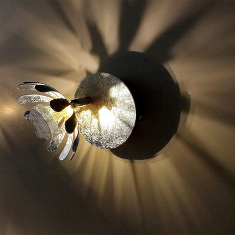 LED Wandlampe Bloom Silberfarben mit blütenförmigem Design und warmweißem Lichtumfeld.