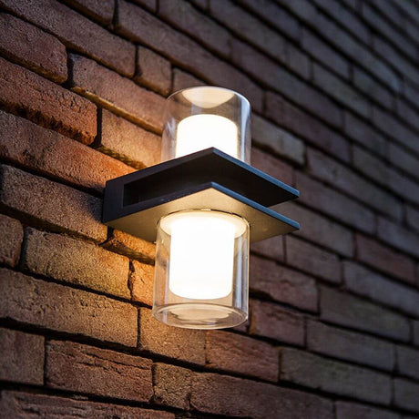 LED Außenwandlampe Tango IP44 Anthrazit an einer Ziegelwand, Licht strahlt nach oben und unten.