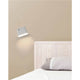 LED Wandleuchte AUREA 6W 2700K Weiß an einer Wand über einem Bett.