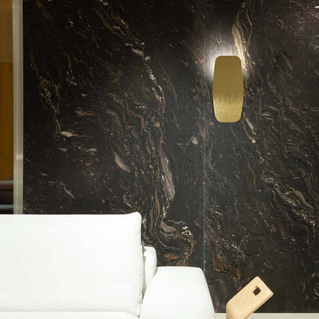 LED-Wandleuchte Ashiya an einer eleganten dunklen Wand mit marmorierter Oberfläche, moderne Ausstattung.