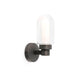 LED-vegglampe BRUME 3W 2700K IP44 bronse på veggen med glassdeksel og bronsefarget ramme.