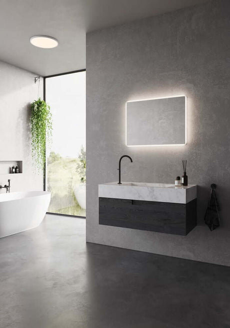 LED Væglampe Dovina 60x80 IP44 oplyser elegant badeværelsesspejl på en moderne væg.