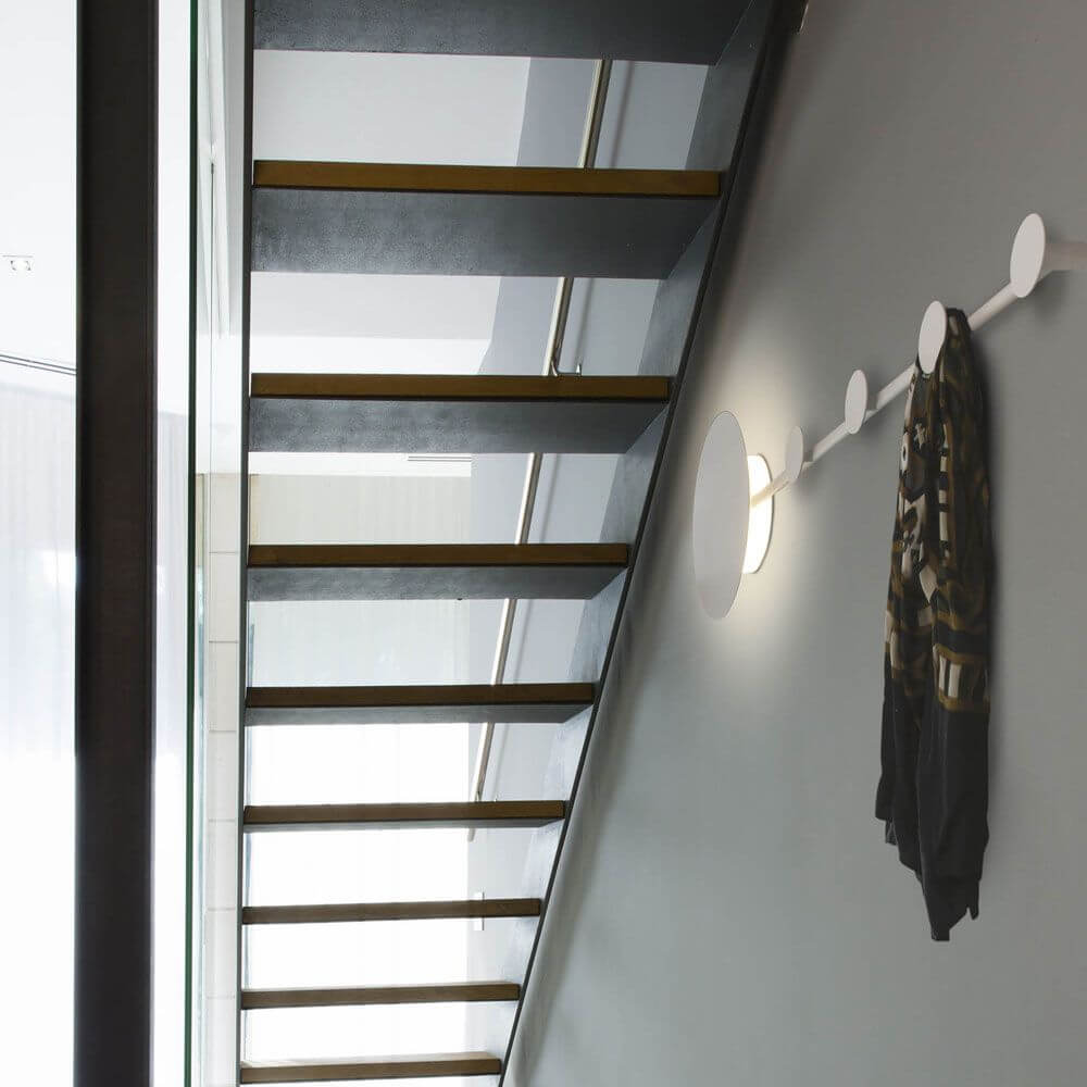 LED Wandleuchte HAN Schwarz Garderobenhaken an einer Wand neben Treppe mit Schal aufgehängt.