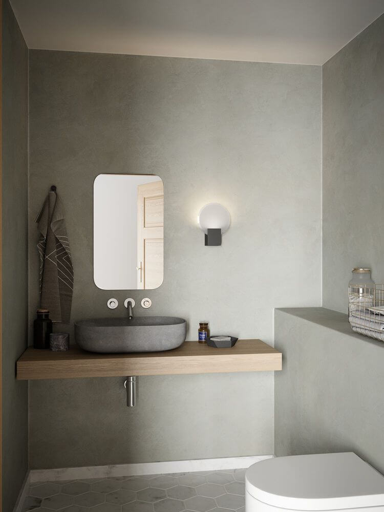 LED Wandleuchte Hester IP44 im modernen Badezimmer mit Holzregal und runder Spiegelfläche.