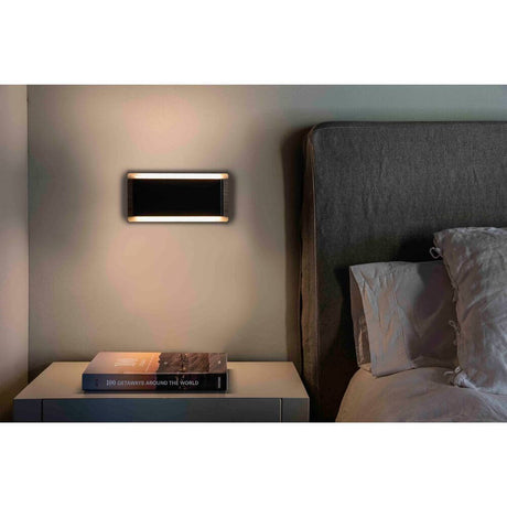 LED Wandleuchte MOOD 2x3W Braun, Schwarz an einer Wand neben einem Bett und Nachttisch.