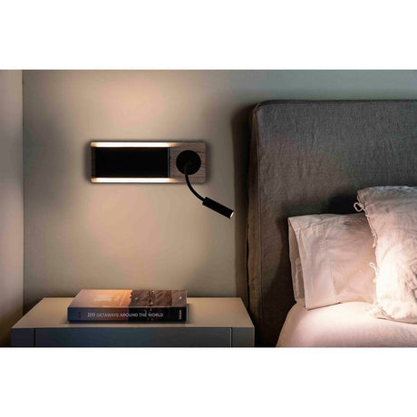 LED MOOD wall light with reading spot 2x3W brown, black on a wall next to a bed.