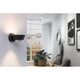LED Wandleuchte Sabik Dimmbar Schwarz an einer Wand in modernem Wohnraum mit Pflanzen und Bildern.