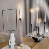 Moderne LED Wandleuchte Shanghai in Schwarz, stilvolles Ambiente mit Kerzen und weißen Deko-Bäumen.