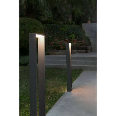 LED Wegeleuchte ALP6W 3000K 80cm IP54 Dunkelgrau in einem Gartenweg bei Nacht.