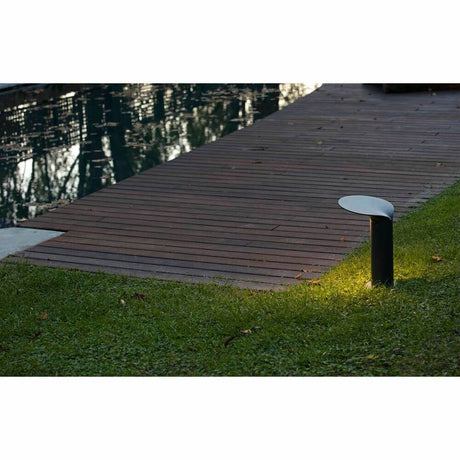 LED Wegeleuchte Lotus 35cm 18W 3000K IP65 Dunkelgrau leuchtet einen Gehweg im Garten.