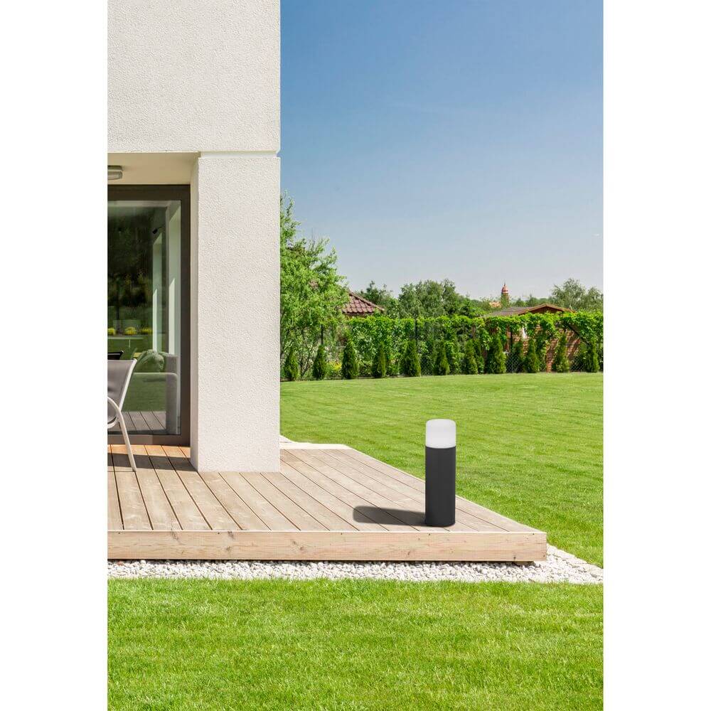 LED Wegeleuchte MUGA IP65 Dunkelgrau auf einer Terrasse im Freien, ideal für Gartenbeleuchtung.