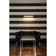 Long Grill LED Wand- und Deckenleuchte Weiß 3000K über schwarzem Sofa in modernem Raum